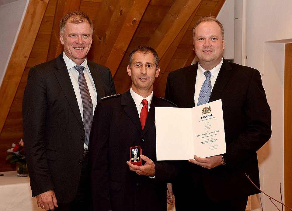 Drei Personen posieren für ein Foto bei der Ehrung von Thomas Wagmüller